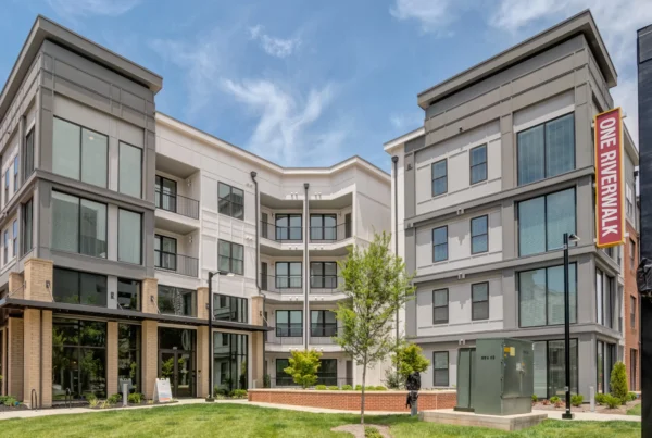 A view of the apartment complex situated at the intersection of two streets, showcasing its architectural design and surroundings.