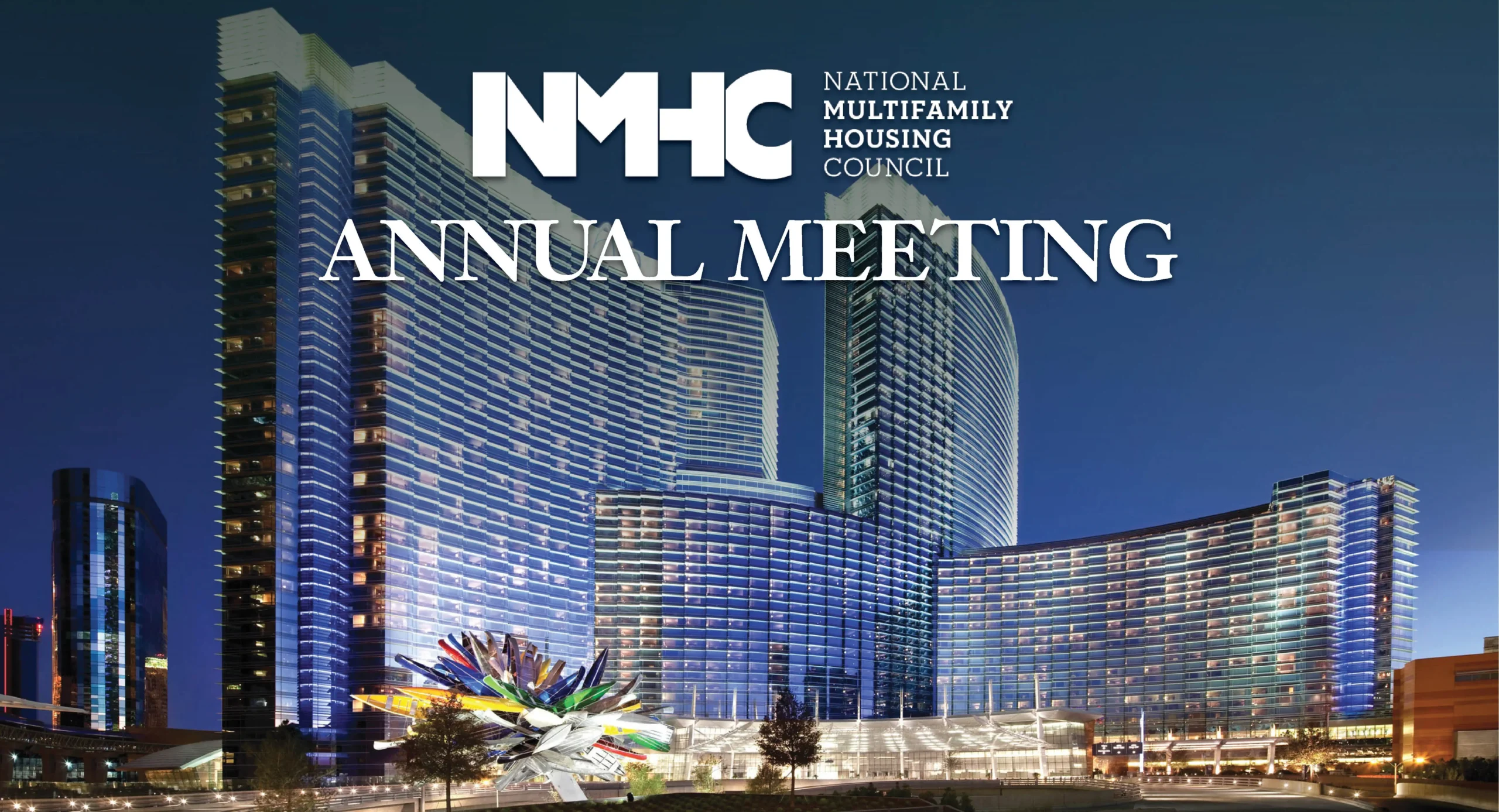 The image advertises the National Multifamily Housing Council (NMHC) Annual Meeting, with the organization's logo prominently displayed. The background features a vibrant night view of modern skyscrapers, illuminated with reflective lights, highlighting a large glass structure and a colorful artistic sculpture in the foreground.