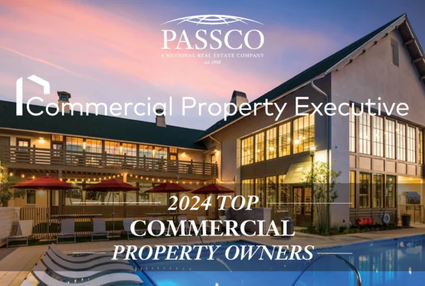 "2024 TOP COMMERCIAL PROPERTY OWNERS" text superimposed over an image of a large building with multiple levels, patio area, pool, and lounge chairs. The sky is painted with hues of pink and blue, indicating sunrise or sunset.