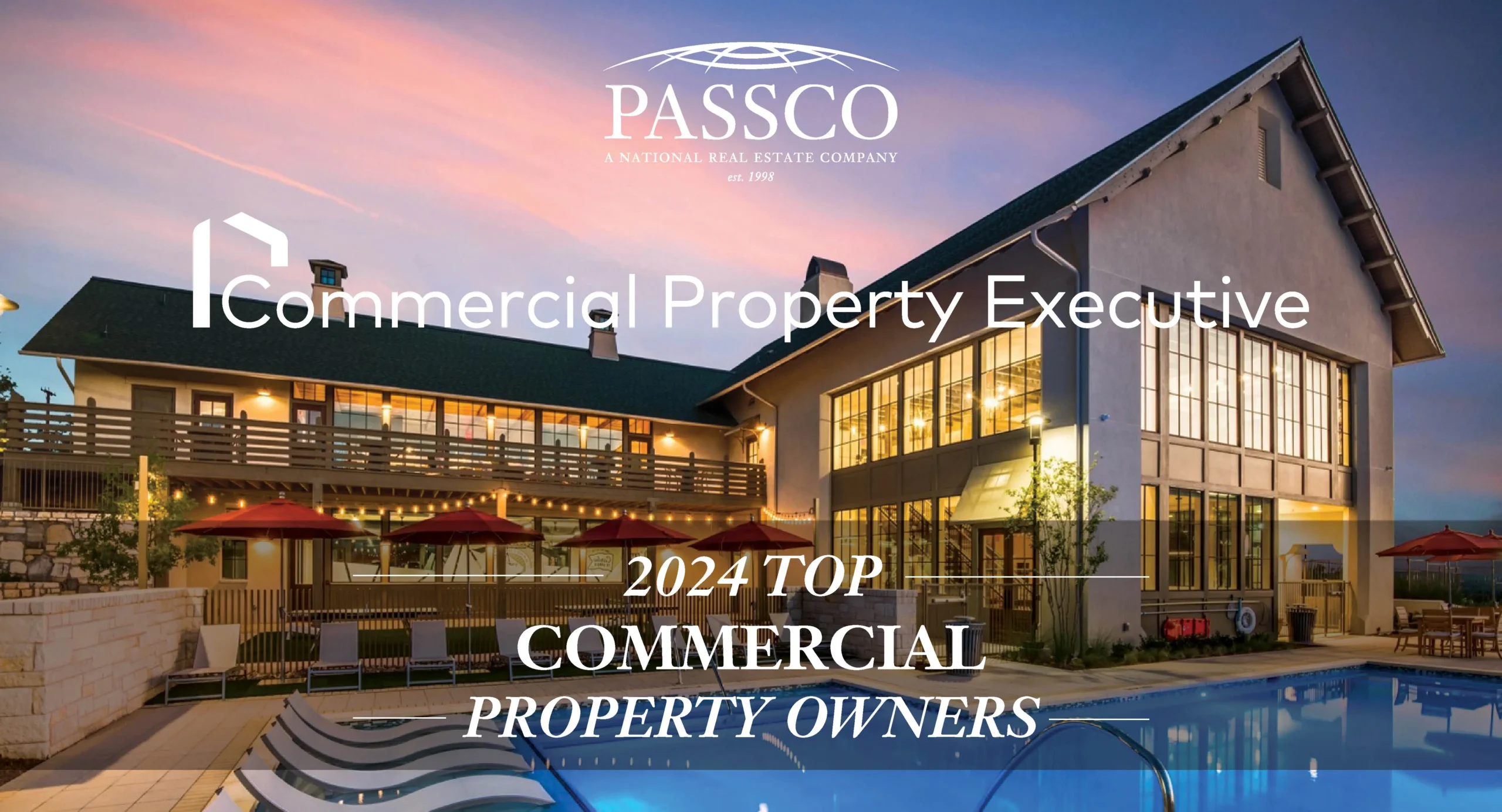 "2024 TOP COMMERCIAL PROPERTY OWNERS" text superimposed over an image of a large building with multiple levels, patio area, pool, and lounge chairs. The sky is painted with hues of pink and blue, indicating sunrise or sunset.